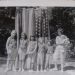 Six little girls and their mother in front of a flag