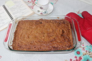 Cinnamon coffee cake with red oven mitt and tea cup