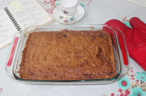 Cinnamon coffee cake with red oven mitt and tea cup